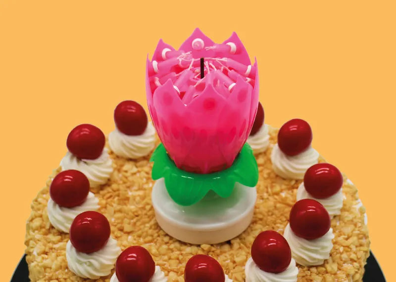 Flower candle sitting on a cake.